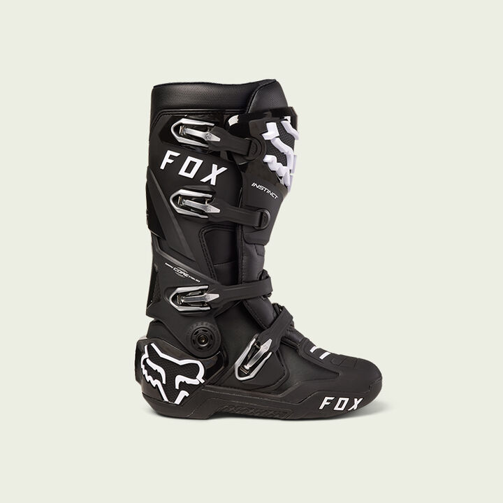 Black motocross boot on green background